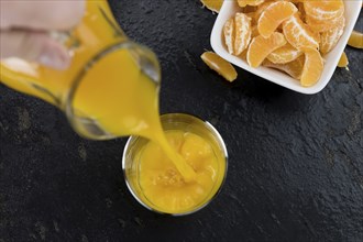 Fresh made Tangerine Juice on a vintage slate slab (selective focus)