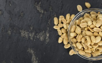 Portion of roasted and salted Peanuts (close-up shot, selective focus)