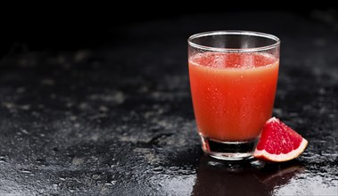 Portion of freshly squeezed Grapefruit Juice on a vintage background (selective focus, close-up