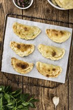 Portion of healthy Empanadas on an old wooden table (selective focus, close-up shot)