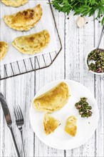 Portion of healthy Empanadas on an old wooden table (selective focus, close-up shot)