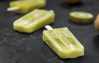 Kiwi Popsicles on a vintage looking slate slab (selective focus)