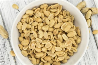 Portion of roasted and salted Peanuts (close-up shot, selective focus)