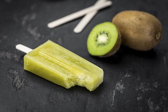 Portion of fresh made Kiwi Popsicles on a slate slab (selective focus)