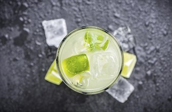 Caipirinha made with fresh limes, ice and sugar as close-up shot