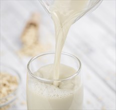 Wooden table with Oat Milk (detailed close-up shot, selective focus)