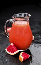 Portion of freshly squeezed Grapefruit Juice on a vintage background (selective focus, close-up