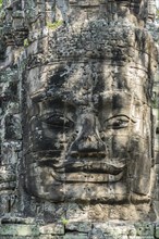 An ancient statue on top of a gate at Ankor Thom in Cambodia