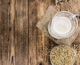 Wooden table with Oat Milk (detailed close-up shot, selective focus)