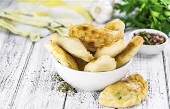 Portion of healthy Empanadas on an old wooden table (selective focus, close-up shot)