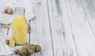 Healthy Ginger Sap on a wooden table as detailed close-up shot (selective focus)