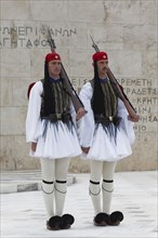 Two Evzones in traditional dress stand guard in front of the parliament building, Tomb of the