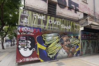 Street corner with portrait of a sprayer on an abandoned shop, street art in Exarchia,