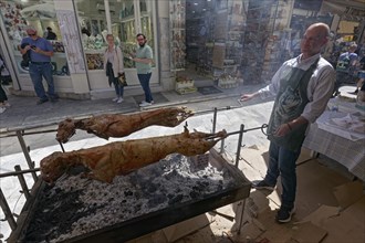 Man grilling lambs on a spit in front of a taverna, Easter lamb, Plaka neighbourhood, Athens,