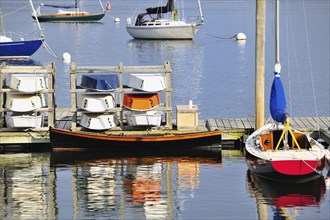 Rockland Harbor Maine USA with colorful sailboats, dinghies and rowboats moored along the dock and