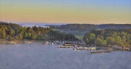 Sweeping panoramic view of boats moored amid the islands of the Stockholm Archipelago at dawn on a