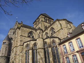 An imposing, historic church building with an elaborately designed faÃ§ade under a blue sky, trier,