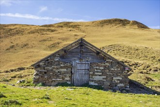 Stone mountain hut in a meadow under a clear blue sky, saas Fee, Alps, Switzerland, Europe