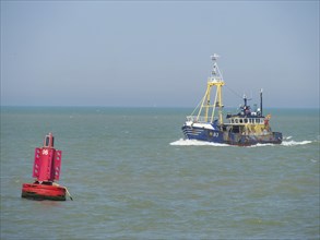 Boat sailing on the sea, next to a red buoy, under a clear sky, oostende, Belgium, Europe