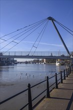 Bridge over a river with seagulls swimming in the water and boat traffic, harbour in the