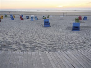 Beach promenade with scattered beach chairs at sunset, langeoog, germany