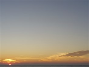 A calm sunset over the sea that bathes the sky in soft colours, langeoog, germany