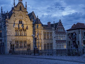 Historic buildings illuminated at dusk under a blue sky, Ghent, Belgium, Europe