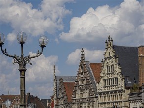 Street lamp and historic gabled houses in Gothic style under a cloudy sky, Ghent, Belgium, Europe