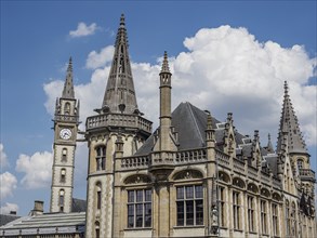 Gothic-style building with high towers under a slightly cloudy sky, Ghent, Belgium, Europe