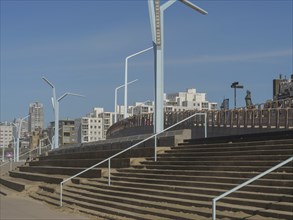 Steps with modern railings and city background under a blue sky, scheveningen, the netherlands