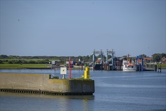 Harbour view with boats and harbour walls, calm water under blue sky, langeoog, germany