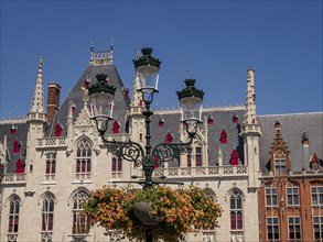 Historic Gothic buildings with a large street lamp and flower arrangements in the foreground,