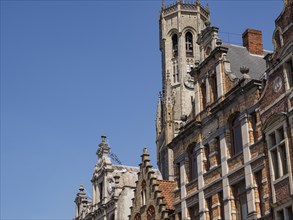 Historic buildings and tower with detailed architecture under a blue sky, Bruges, Belgium, Europe