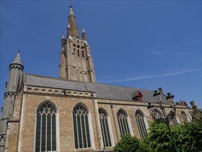 Large Gothic church with towers and large windows in Bruges on a sunny day, Bruges, Belgium, Europe