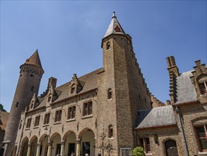 A medieval castle with high towers and an archway, Bruges, Belgium, Europe