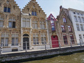 Historic gabled houses along a canal in Bruges with sunny weather in the background, Bruges,