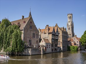 A picturesque canal with boats, surrounded by historic brick buildings and nature, Bruges, Belgium,