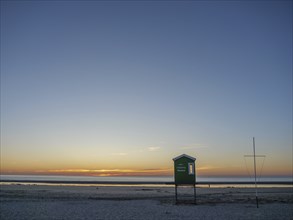 A lonely beach hut at sunset, with a wide sandy beach and the sea in the background, langeoog,