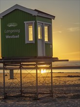 Green beach hut at Westbad on the beach at sunset, langeoog, germany