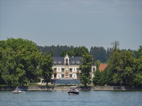 Elegant large building with a tower close to trees and a lake, Lindau, Lake Constance, Germany,