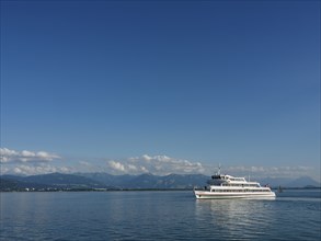 A large ship glides across the calm lake, surrounded by mountains, Lindau, Bavaria, Germany, Europe