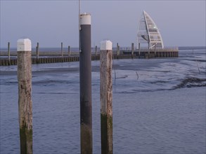 A modern harbour with wooden bollards and a building in the background at dusk, Juist, East Frisia,