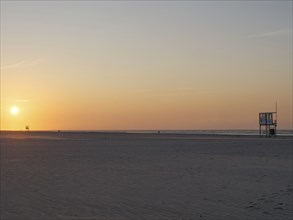 Sunset on the beach with a view of the sea and a watchtower, juist, east frisia, Germany, Europe