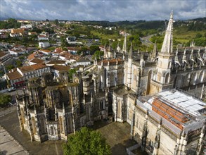 Gothic cathedral with detailed façade in the middle of an urban landscape with houses and green