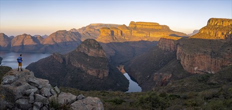 Tourist enjoying the view from a rock, Panorama, Sunset at Blyde River Canyon with Three Rondawels