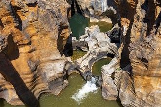 Eroded rock formations, canyon with steep orange-coloured rock cliffs with the Blyde River,