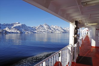 Boat trip with views of snow-capped mountains and calm waters under a blue sky, ferry along the