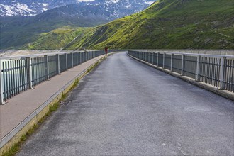 Hiker crossing the Moiry dam, near Grimentz, Val d'Anniviers, Valais Alps, Canton Valais,