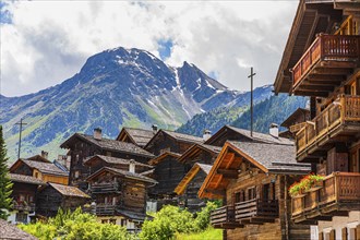 Nested old wooden houses, behind the summit of the Scex de Marenda mountain, historic village