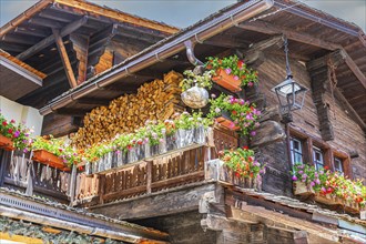 Nested old wooden house with lantern on the roof and flower boxes in front of windows and